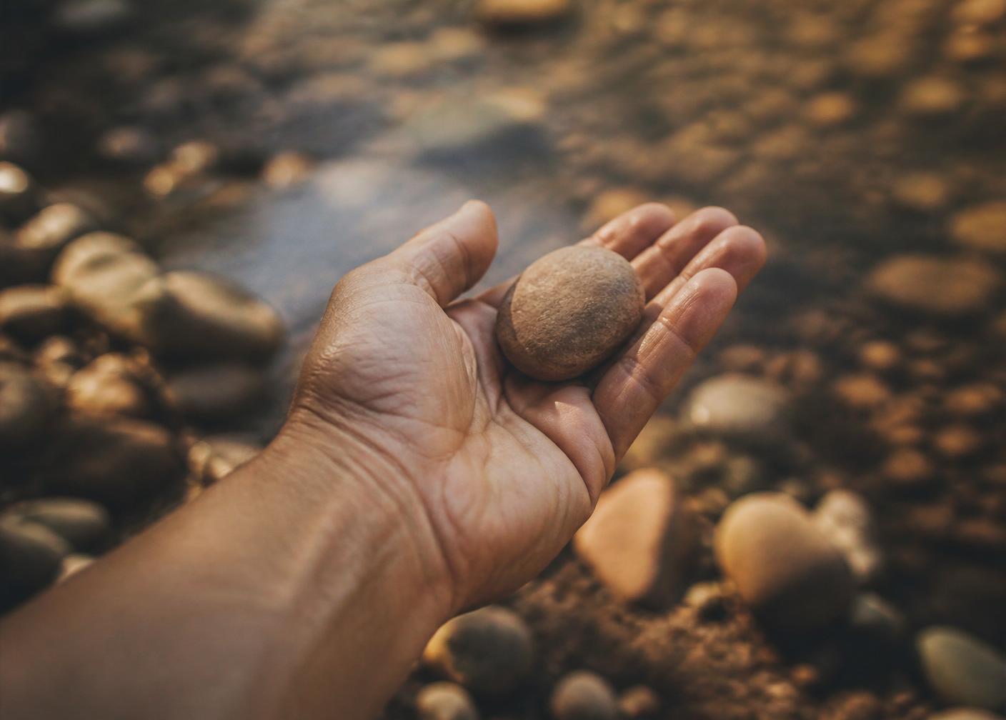 A hand cradling a smooth river stone